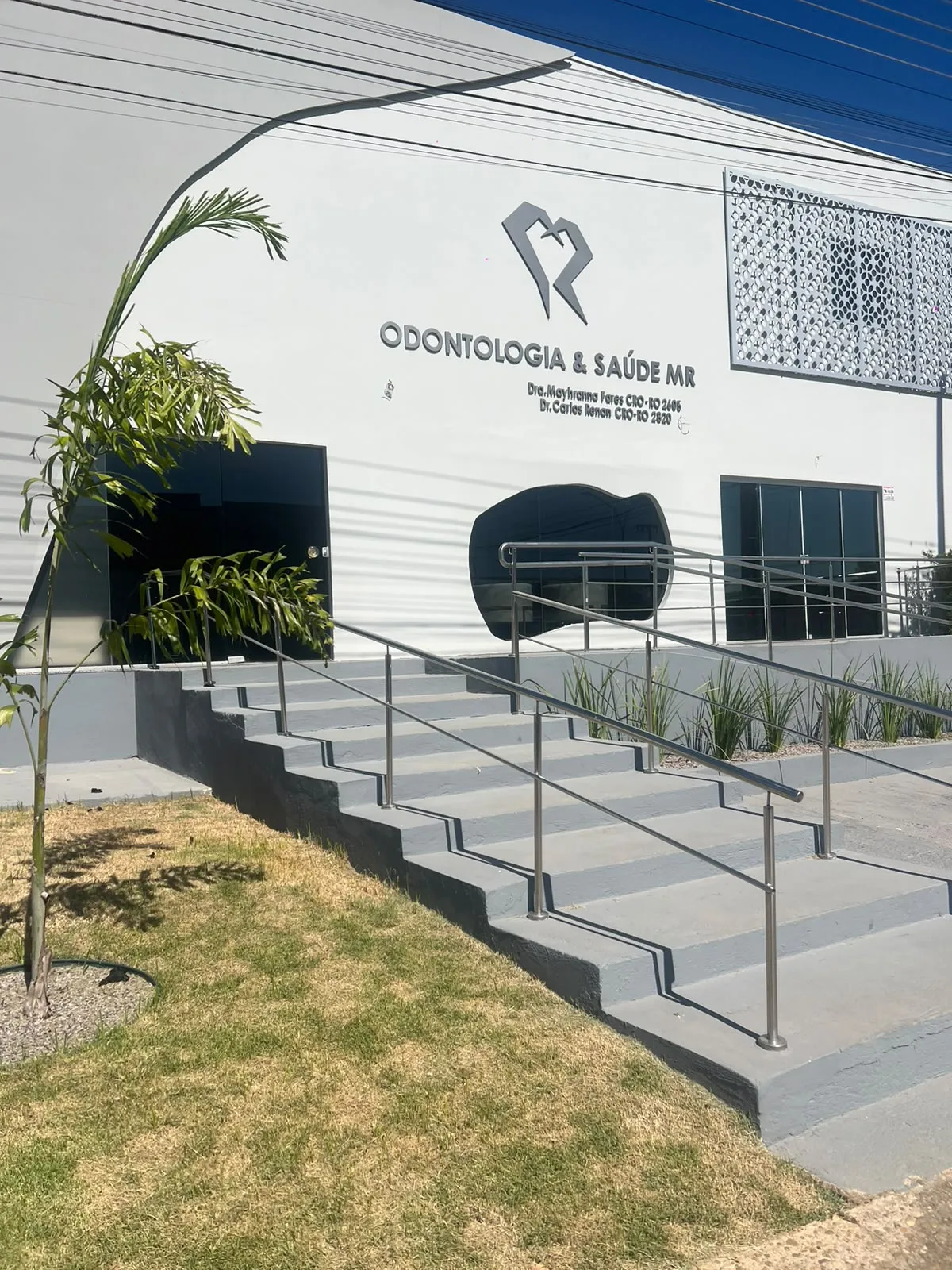 Fachada da Clínica MR – Odontologia & Saúde, com o emblema MR, escadaria e rampa de acesso